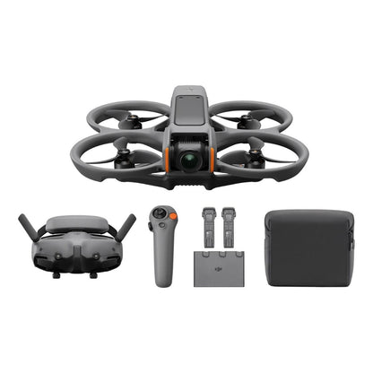Compact FPV drone with propeller guards and camera hovering low over a grassy field